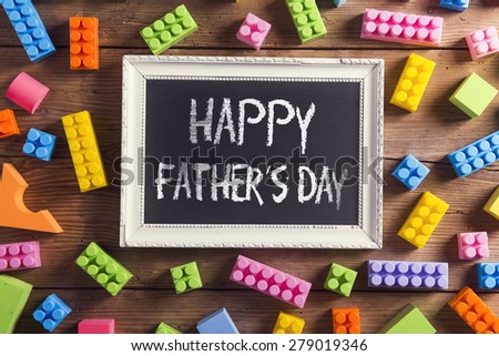 Picture frame with Happy fathers day sign laid on wooden backround.