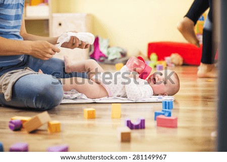 Young hipster father changing nappy to his little baby daughter
