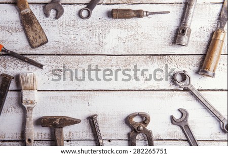 Desk of a carpenter with various tools. Studio shot on a wooden background.