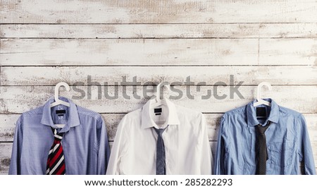 Fathers day composition of shirts and ties hang on wooden wall background.