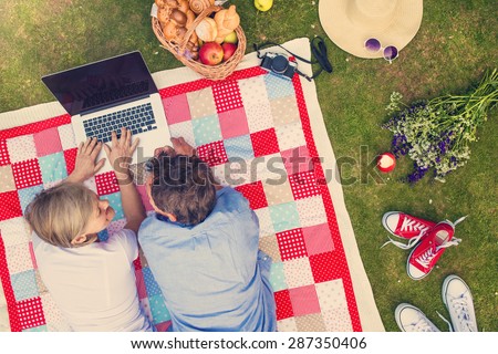 Beautiful seniors with notebook having a picnic in nature