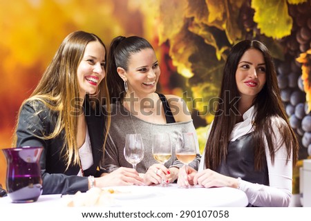 Three beautiful women having fun in a wine bar
