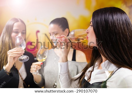 Three beautiful women having fun in a wine bar
