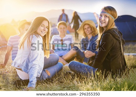 Group of beautiful teens camping at summer festival