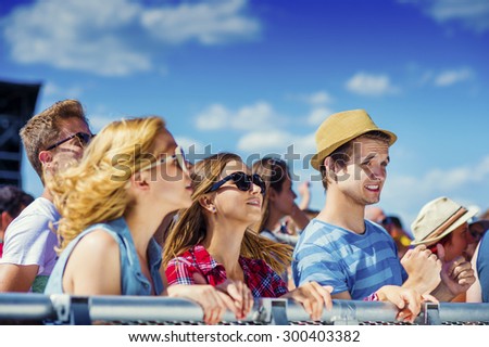 Group of beautiful teens at concert at summer festival