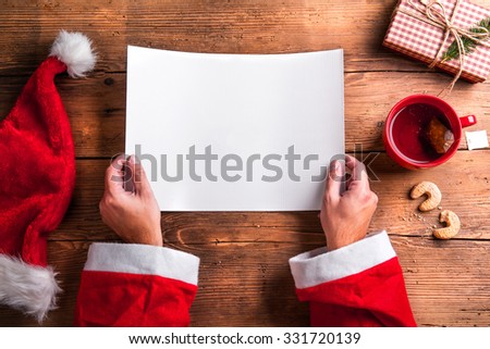 Santa Claus holding an empty wish list in his hands