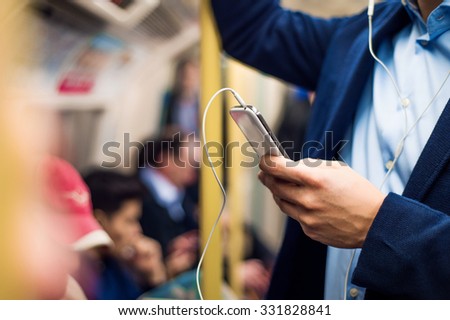 Young handsome businessman with smartphone in subway