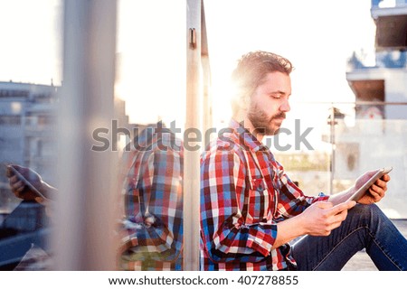 Businessman working from home on tablet, sitting on balcony