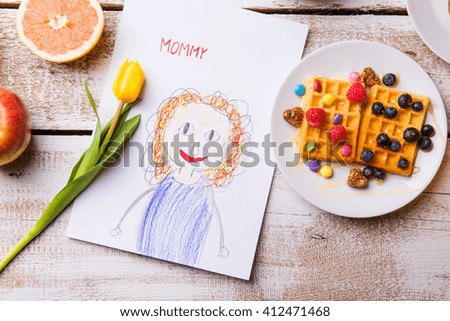 Childs drawing of her mother, yellow tulip, waffles