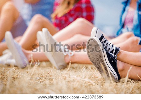 Legs of teenagers, canvas shoes, summer music festival. Young teens at summer music festival. Funny group of young girls and boys at music festival. Happy teen at summer festival.