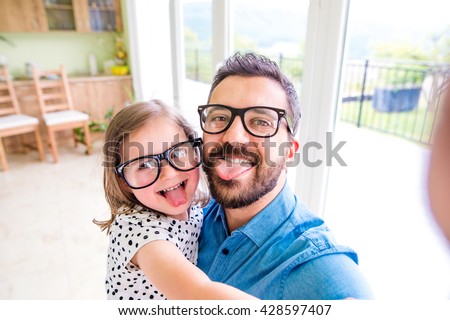 Father with his little daughter sticking tongue out