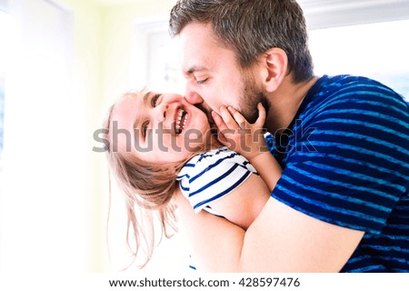 Close up of hipster father kissing his little daughter