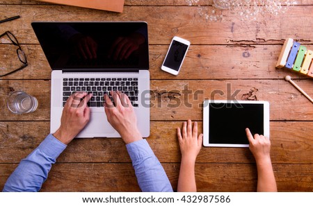Father and son, office desk with laptop and tablet