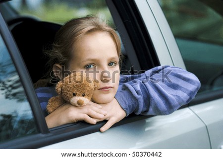 Little girl in car is going to miss her friends.