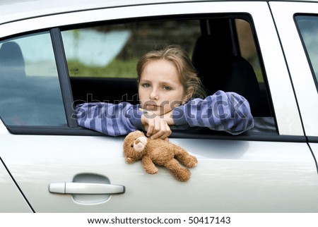 Little girl in car is going to miss her friends.