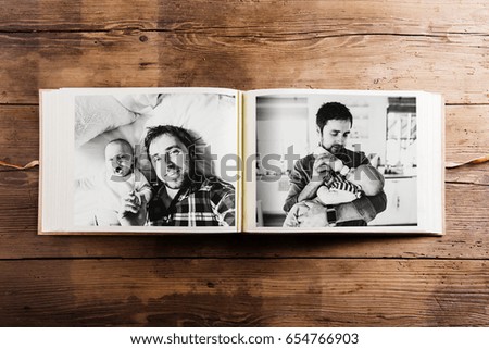 Photo album with pictures of father and baby son. Fathers day.