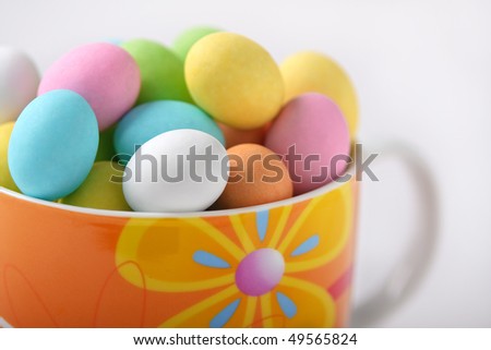 Cup full of colored easter eggs on a white background
