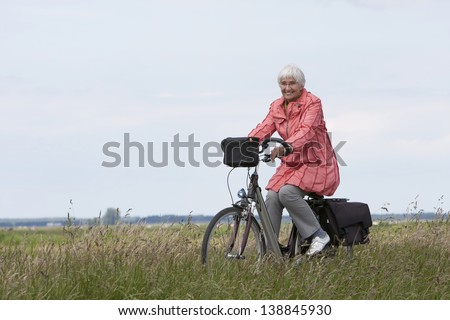 Elderly woman on a bicycle in a Dutch polder