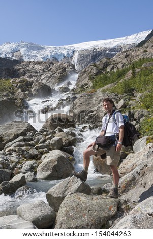 Man and a waterfall (Buarbreen glacier, Folgefonna National Park, Norway)