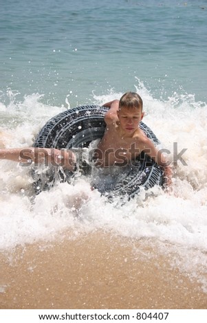 Child on swimming belt on the ocean surf