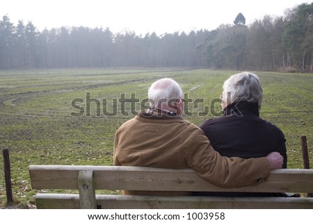 Elderly couple sitting on a bank in nature