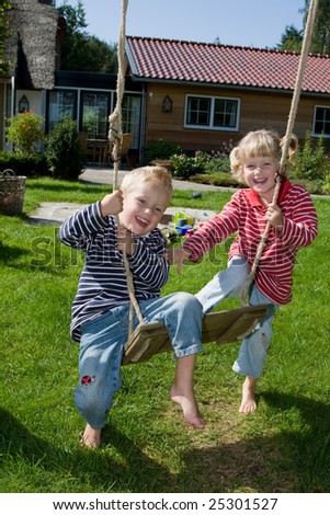 stock photo : Little twins playing on a swing stock photo : Little twins playing on a swing