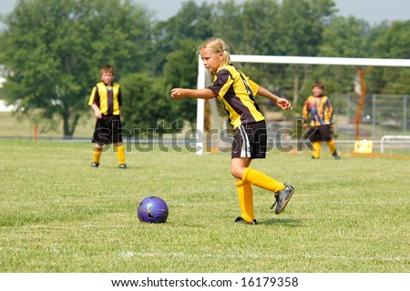 Young soccer girl prepares to kick ball during play