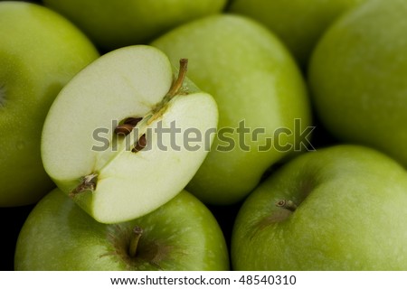 A group of Green Apples with a Cut Quarter