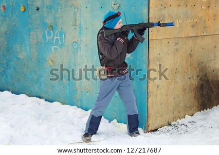 boy in winter clothes with a machine gun to play laser tag