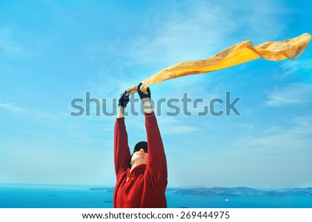 Freedom Concept.Girl with  Scarf standing on the Rock. Flying.Free.Vacation