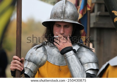 MILOVICE, CZECH REPUBLIC - OCTOBER 23, 2013: Actor dressed as a medieval guard smokes during the filming of the new movie The Knights directed by Carsten Gutschmidt near Milovice, Czech Republic.