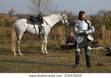 MILOVICE, CZECH REPUBLIC - OCTOBER 23, 2013: Actor dressed as a medieval knight and his horse during the filming of the new movie The Knights near Milovice, Czech Republic.