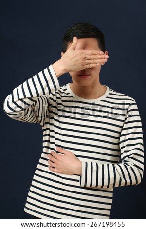 Young Asian man covering his face by palm