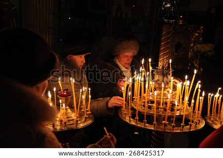 PSKOV, RUSSIA - JANUARY 18, 2011: Orthodox believers light candles during the Epiphany evening service in the Church of Saint Alexander Nevsky in Pskov, Russia.