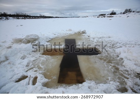 Cross-shaped ice hole called the Jordan for the Epiphany bathing in the Velikaya River at the Vybuty Pogost near Pskov, Russia.