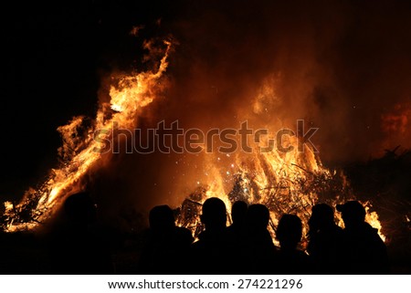 BURG, GERMANY - APRIL 23, 2011: People look at the traditional Easter bonfire in the Lusatian village of Burg in Spreewald Region, Lower Lusatia, Brandenburg, Germany.