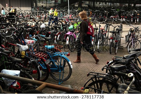 AMSTERDAM, NETHERLANDS - AUGUST 9, 2012: Woman walks through the bicycle parking station next to the Central railway station in Amsterdam, Netherlands.