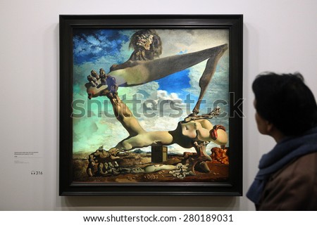 PARIS, FRANCE - JANUARY 7, 2013: Visitor looks at the painting Soft Construction with Boiled Beans or Premonition of Civil War (1936) by Salvador Dali at his retrospective exhibition in Paris, France.