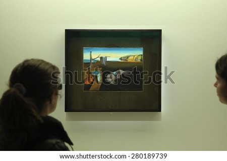 PARIS, FRANCE - JANUARY 7, 2013: Visitors look at the painting The Persistence of Memory (1931) by Salvador Dali displayed at his retrospective exhibition in Paris, France.