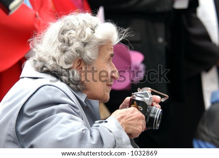 Old Paparazzi: an old woman taking photos with a retro camera.
