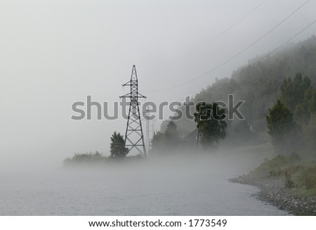 Angara River in Siberia, Russia, in the morning fog with power line towers