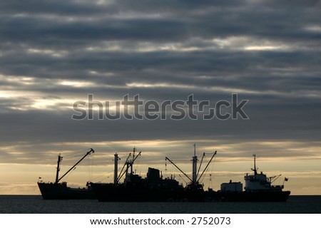 Cargo boats loading at sunset