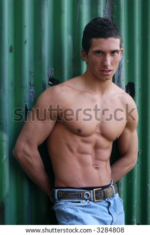Shirtless muscular male model in front of the green crimping metal wall