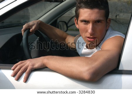 Young muscular driver sitting in the car