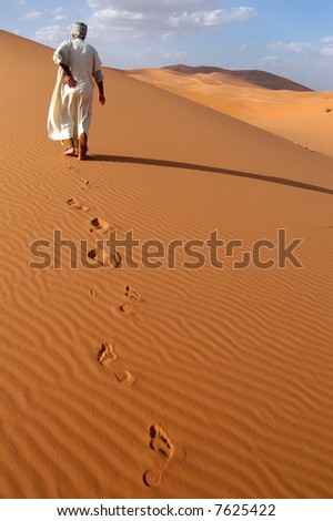 Lonely Berber man going ahead through the Sahara Desert in Morocco