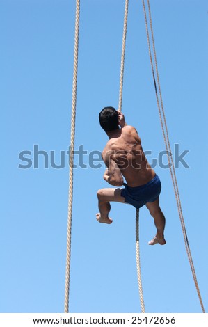 PRAGUE, JUNE 17 - Shirtless athlete climbing up the rope during a rope-climbing competition in Prague, Czech Republic, on June 17, 2008