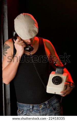 Handsome man talking on an old style telephone.
