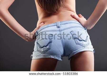 Closeup of a girl\'s behind in hot pants, with her hands on her waist.