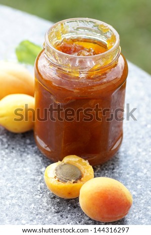 Glass with apricot jam and fresh apricots