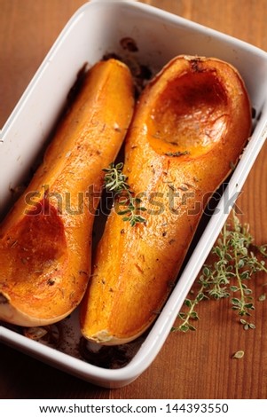 Tray with baked butternut squash and herbs.